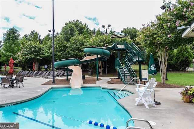 community pool featuring a patio area and a water slide