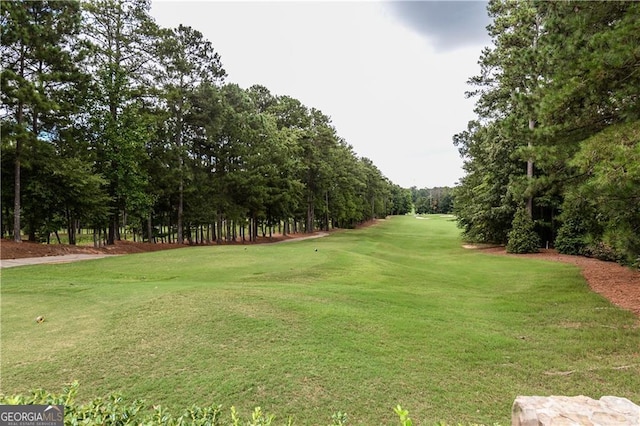 view of home's community with a lawn and view of golf course