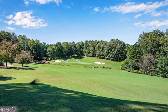 surrounding community featuring a lawn and golf course view