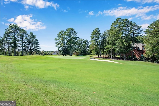 view of property's community featuring a yard and view of golf course