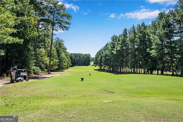 surrounding community featuring a lawn and view of golf course