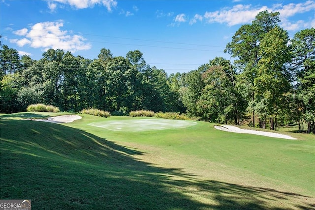 surrounding community featuring golf course view and a yard
