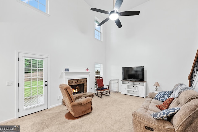 449 Highlands Loop, Woodstock, GA 30188 - carpeted living area featuring a towering ceiling, a stone fireplace, ceiling fan, and baseboards