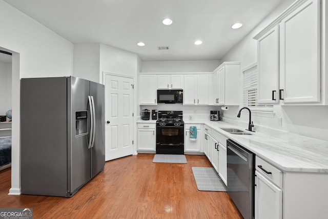 449 Highlands Loop, Woodstock, GA 30188 - kitchen featuring black appliances, a sink, white cabinetry, light wood-style floors, and light stone countertops