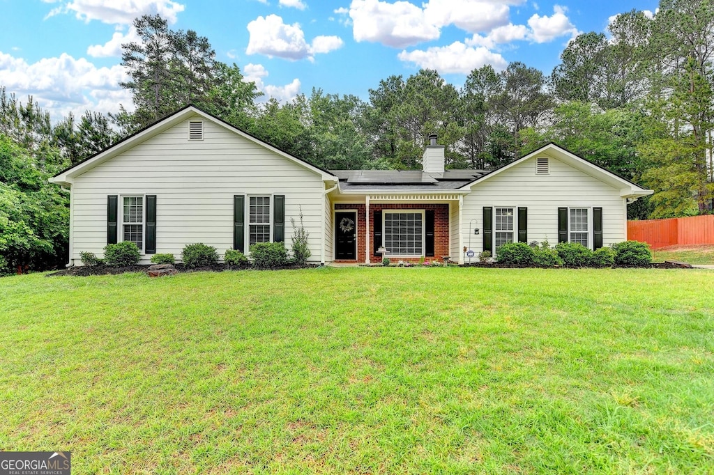 425 Charlyne Way, Dacula, GA 30019 - ranch-style home with a front lawn, fence, a chimney, brick siding, and solar panels