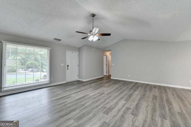 unfurnished living room featuring a ceiling fan, a textured ceiling, visible vents, and wood finished floors