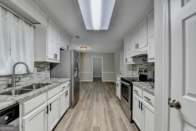 kitchen with backsplash, a sink, baseboards, under cabinet range hood, and stainless steel appliances