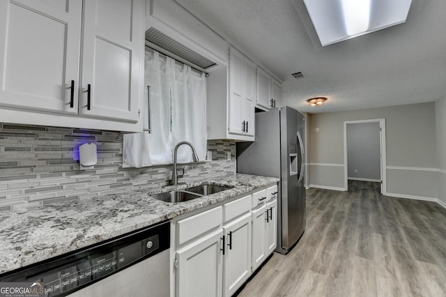 kitchen featuring visible vents, a sink, backsplash, and stainless steel appliances