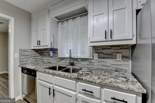 kitchen with decorative backsplash, a sink, baseboards, stainless steel appliances, and white cabinetry