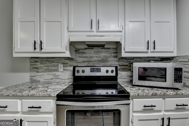 kitchen with decorative backsplash, white cabinetry, under cabinet range hood, and stainless steel appliances