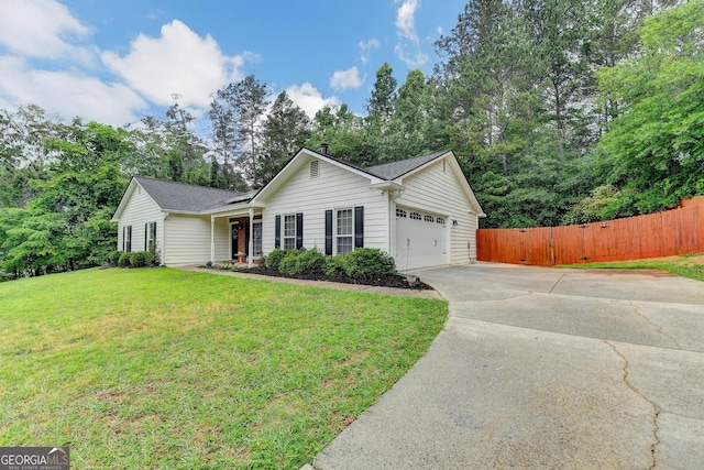 ranch-style house with an attached garage, fence, driveway, and a front yard