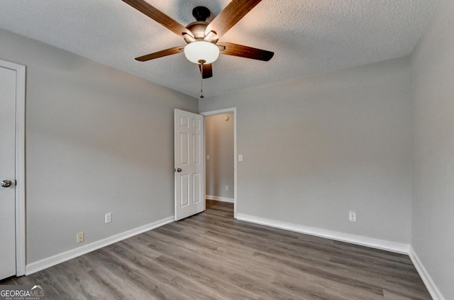 unfurnished bedroom with baseboards, a textured ceiling, and wood finished floors