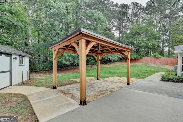 view of patio / terrace with a gazebo, fence, and an outdoor structure