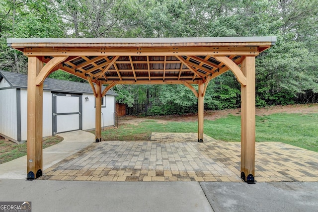 view of patio / terrace with an outdoor structure, fence, a storage shed, and a gazebo