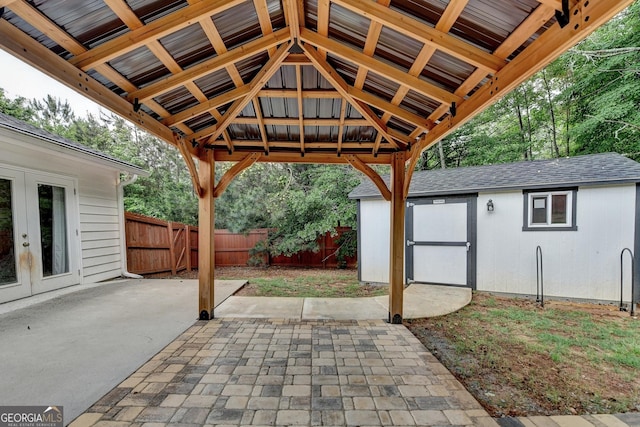 view of patio / terrace featuring an outbuilding, fence, and french doors