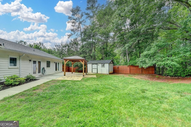 view of yard featuring fence, a patio area, a gazebo, a storage shed, and an outbuilding