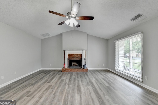 unfurnished living room with a ceiling fan, wood finished floors, and visible vents