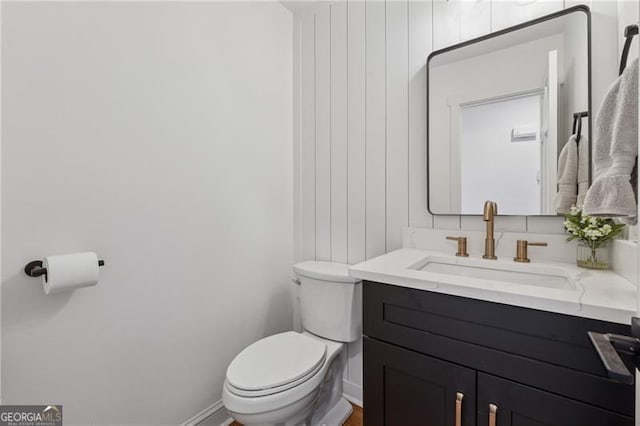 bathroom featuring vanity, baseboards, and toilet