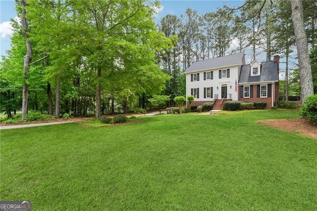 view of front of house with a chimney and a front yard