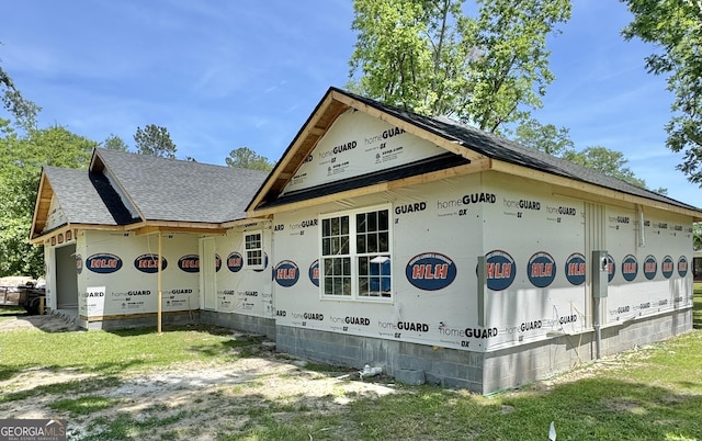 view of side of property with roof with shingles and crawl space