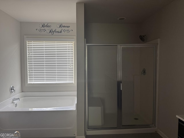 bathroom featuring a bath and a shower stall