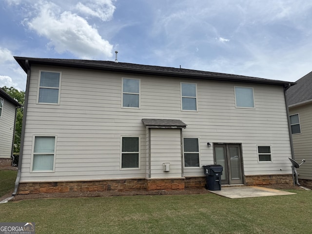 back of house with a lawn and a patio area