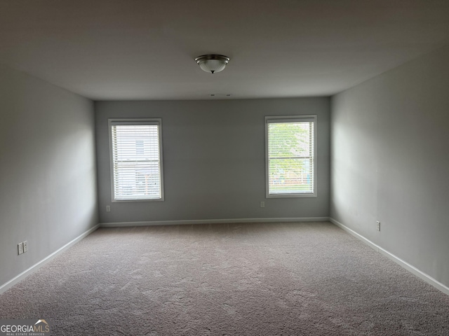 carpeted spare room featuring baseboards