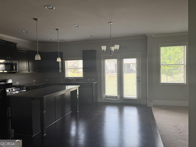 kitchen with decorative backsplash, crown molding, appliances with stainless steel finishes, a sink, and dark cabinets