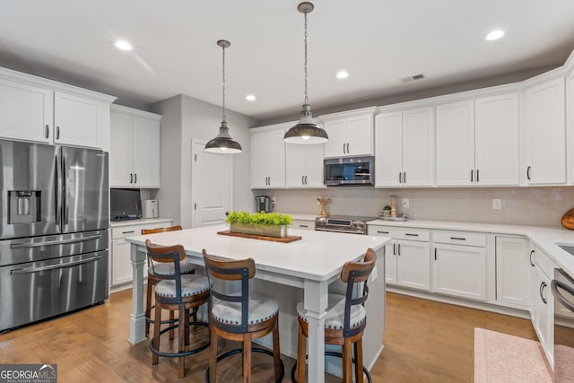 kitchen with visible vents, white cabinets, and stainless steel appliances