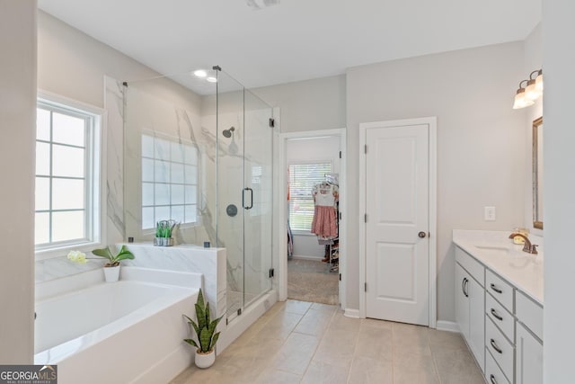 bathroom with tile patterned floors, a marble finish shower, a bath, and vanity