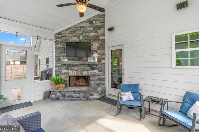 view of patio / terrace featuring ceiling fan and an outdoor stone fireplace
