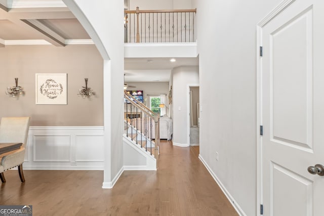 entryway featuring arched walkways, ceiling fan, stairs, and wood finished floors