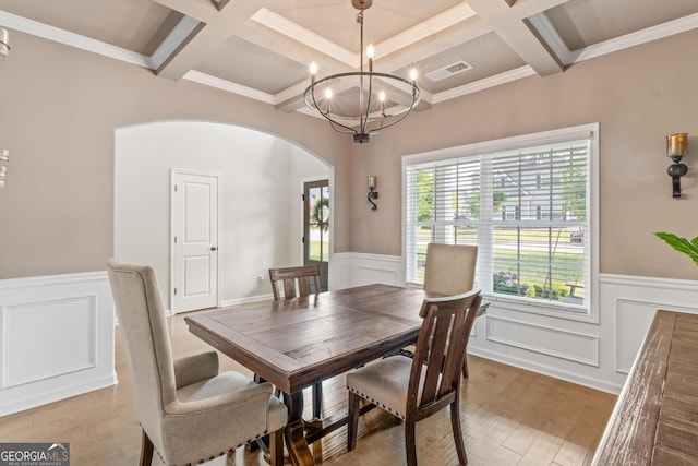 dining space with visible vents, arched walkways, a wainscoted wall, coffered ceiling, and light wood-style flooring