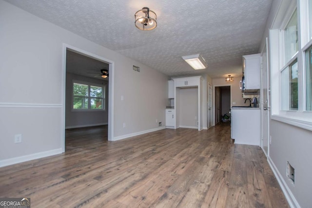 6213 Cherry Ln, Douglasville, GA 30134 - unfurnished living room with dark wood-style floors, ceiling fan, a textured ceiling, and baseboards