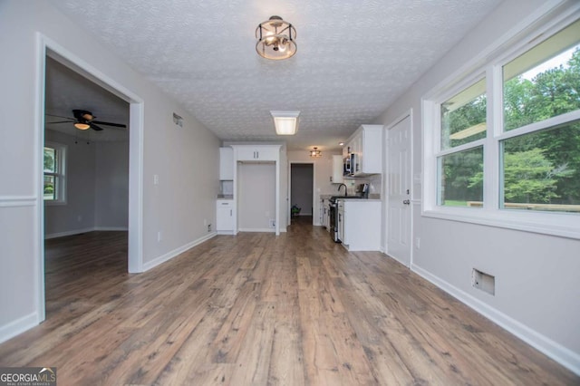 6213 Cherry Ln, Douglasville, GA 30134 - unfurnished living room with wood finished floors, a textured ceiling, baseboards, and ceiling fan