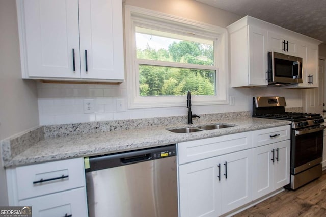 6213 Cherry Ln, Douglasville, GA 30134 - kitchen with stainless steel appliances, a sink, white cabinetry, tasteful backsplash, and a textured ceiling