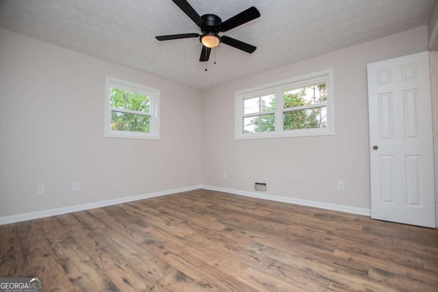 6213 Cherry Ln, Douglasville, GA 30134 - empty room featuring healthy amount of natural light, wood finished floors, baseboards, a textured ceiling, and a ceiling fan