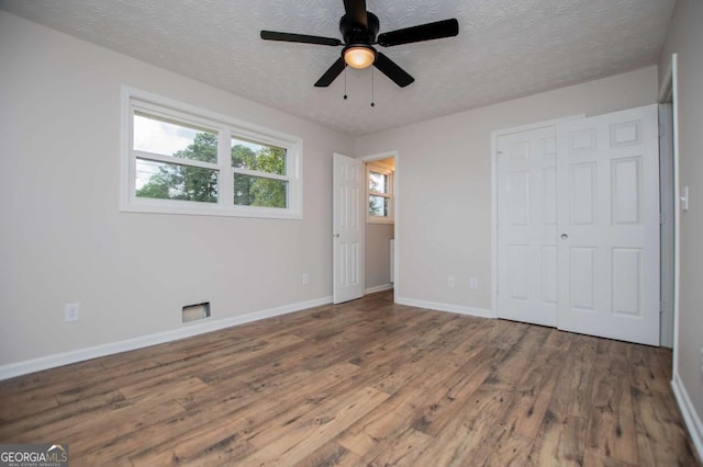 6213 Cherry Ln, Douglasville, GA 30134 - unfurnished bedroom featuring wood finished floors, a textured ceiling, baseboards, a closet, and a ceiling fan