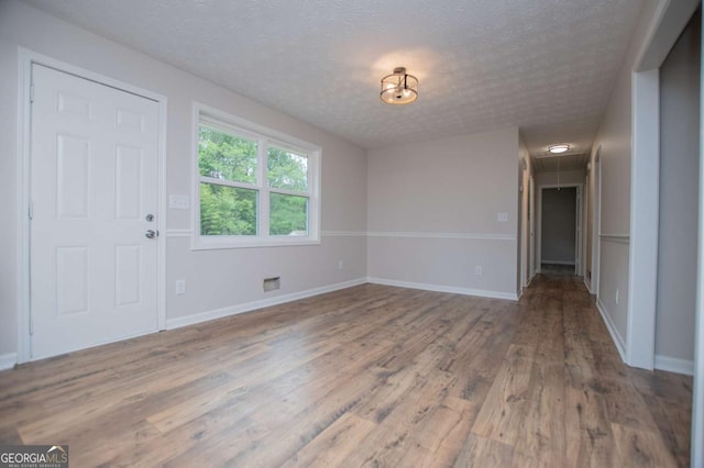6213 Cherry Ln, Douglasville, GA 30134 - unfurnished dining area featuring a textured ceiling, wood finished floors, and baseboards