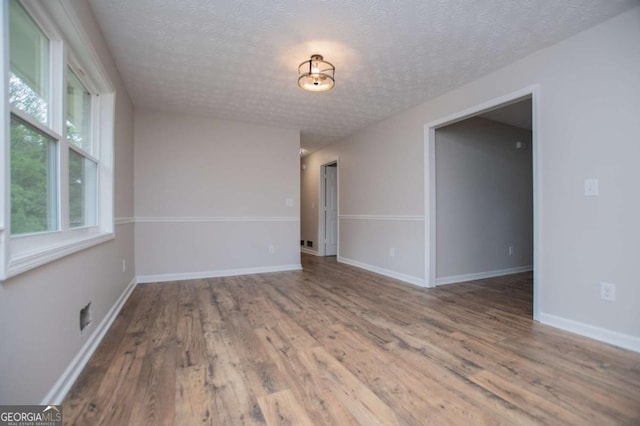 6213 Cherry Ln, Douglasville, GA 30134 - spare room featuring wood finished floors, a textured ceiling, and baseboards
