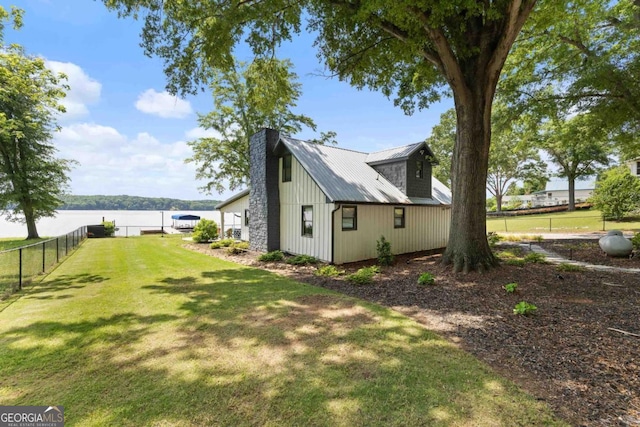 1601 Arrowhead Rd, Greensboro, GA 30642 - view of home's exterior with fence, a chimney, metal roof, a water view, and a yard