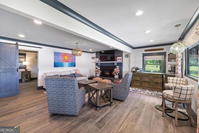 1601 Arrowhead Rd, Greensboro, GA 30642 - living room featuring crown molding, wood finished floors, a stone fireplace, recessed lighting, and a barn door