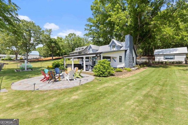 1601 Arrowhead Rd, Greensboro, GA 30642 - rear view of property featuring a fire pit, fence, a patio, a chimney, and a lawn