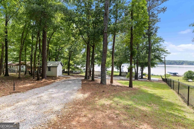 1601 Arrowhead Rd, Greensboro, GA 30642 - view of yard featuring fence, a shed, an outbuilding, a water view, and gravel driveway
