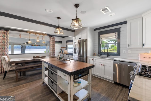 1601 Arrowhead Rd, Greensboro, GA 30642 - kitchen with white cabinets, a sink, stainless steel appliances, visible vents, and pendant lighting