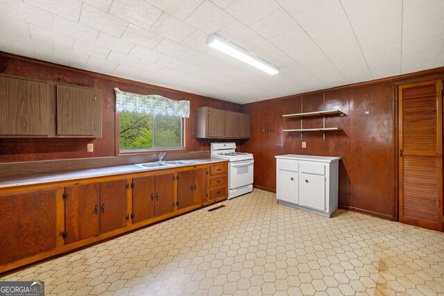 3011 Refuge Rd, Jasper, GA 30143 - kitchen featuring a sink, wood walls, open shelves, light countertops, and white gas stove