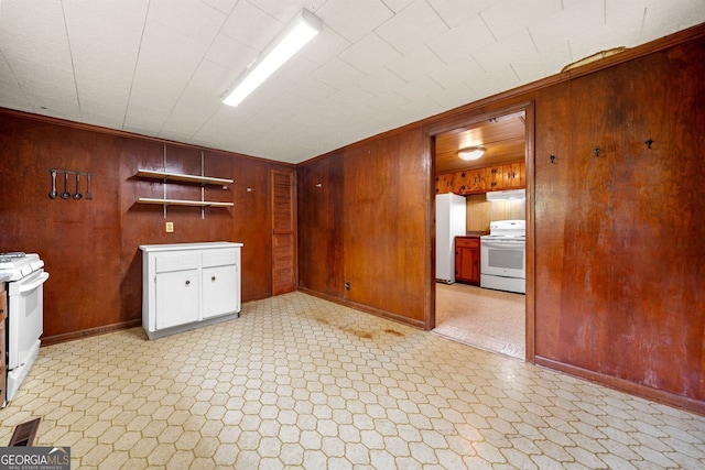 3011 Refuge Rd, Jasper, GA 30143 - kitchen with white electric range oven, white gas range oven, wooden walls, under cabinet range hood, and light flooring