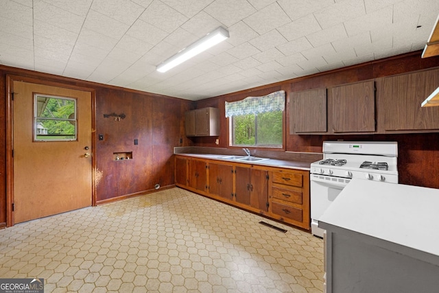 3011 Refuge Rd, Jasper, GA 30143 - kitchen featuring white gas range oven, wood walls, and light countertops