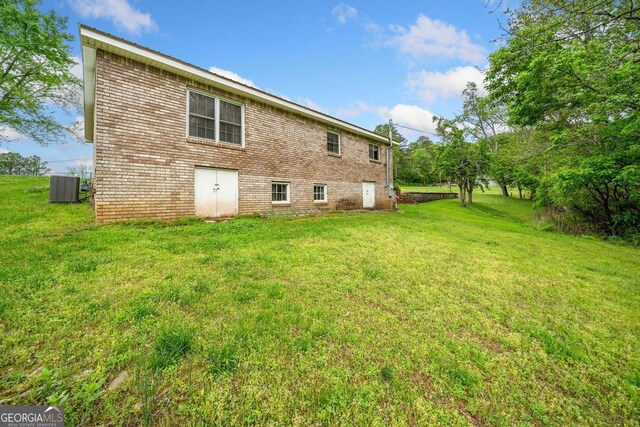 3011 Refuge Rd, Jasper, GA 30143 - back of property with brick siding, a lawn, and central AC