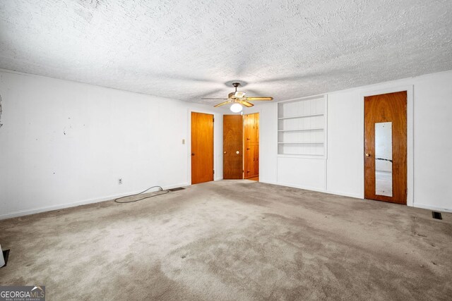 3011 Refuge Rd, Jasper, GA 30143 - unfurnished living room featuring carpet flooring, ceiling fan, and built in shelves
